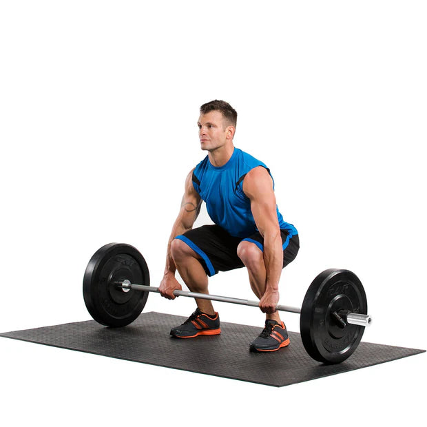 Man performing a barbell squat on a black mat with a white background